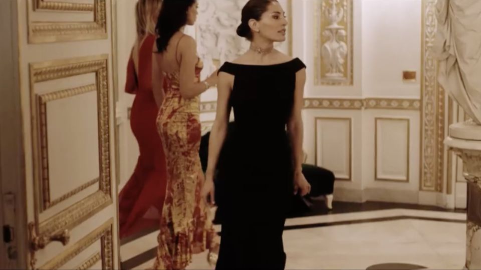 Tre donne in abito da sera in un salone con stucchi dorati, dal video Niente per caso per Cuoio di Toscana